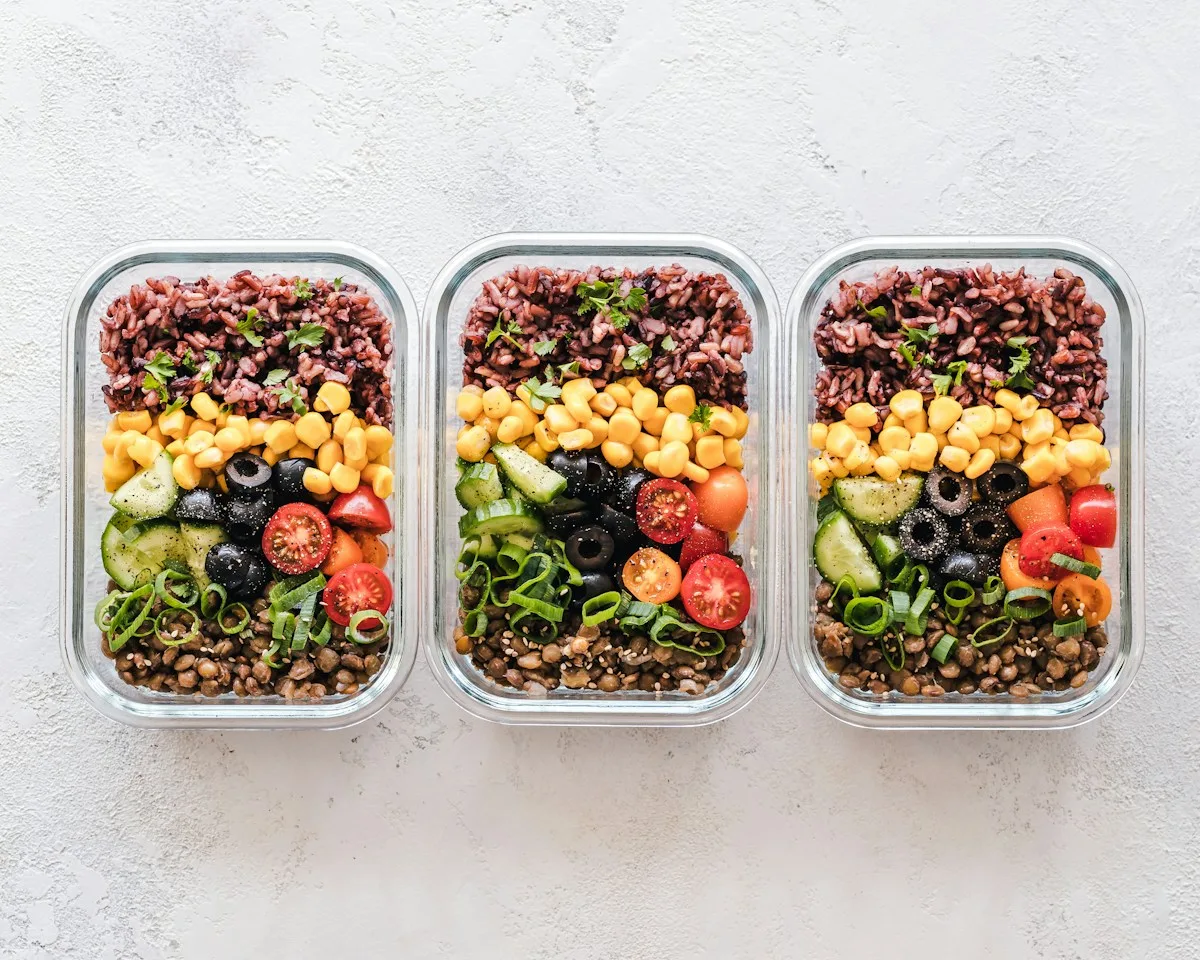 Three prepared meal containers with colorful vegetables and grains