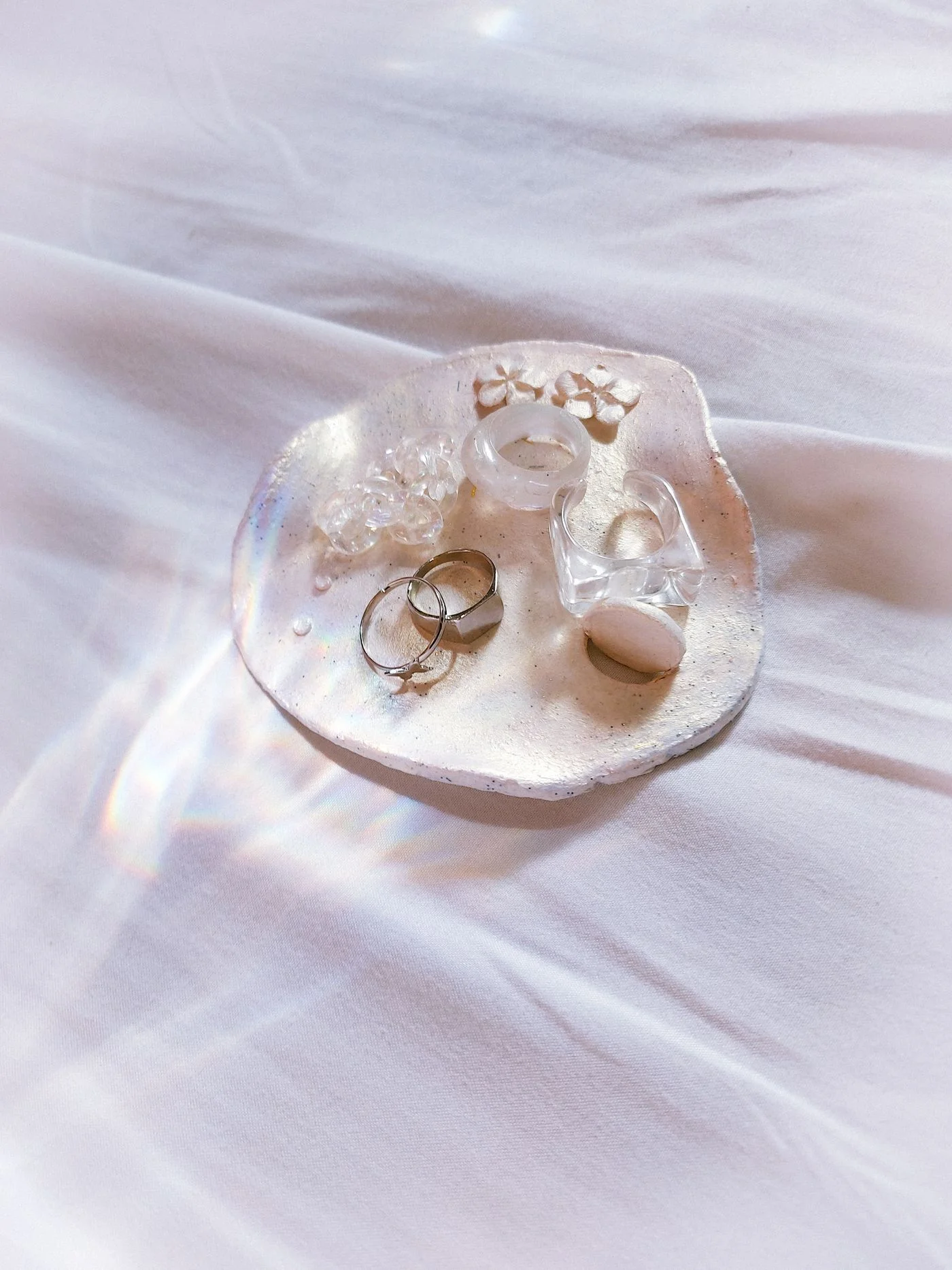Jewellery and crystals arranged on a small decorative dish.