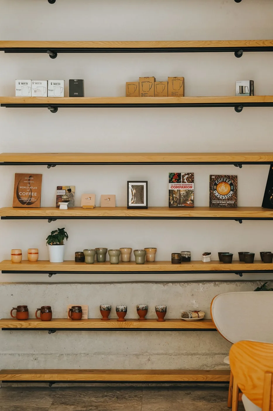 Long wooden kitchen shelves holding books, jars and other items