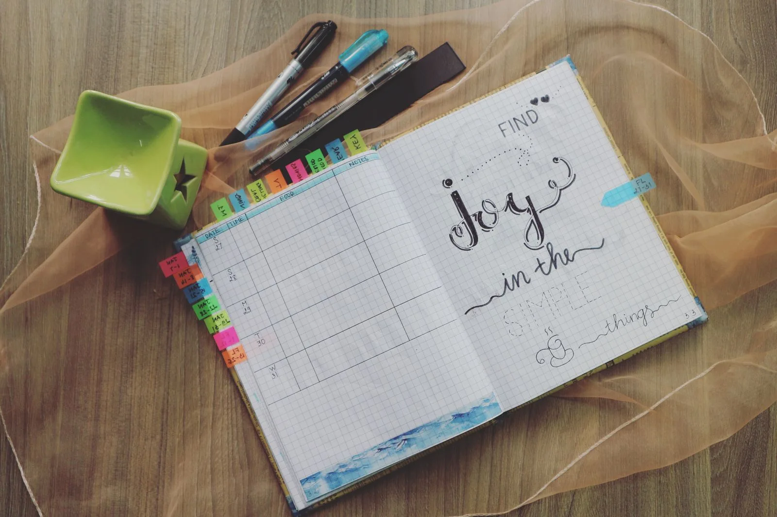 An open planner with pens and small stationery items
