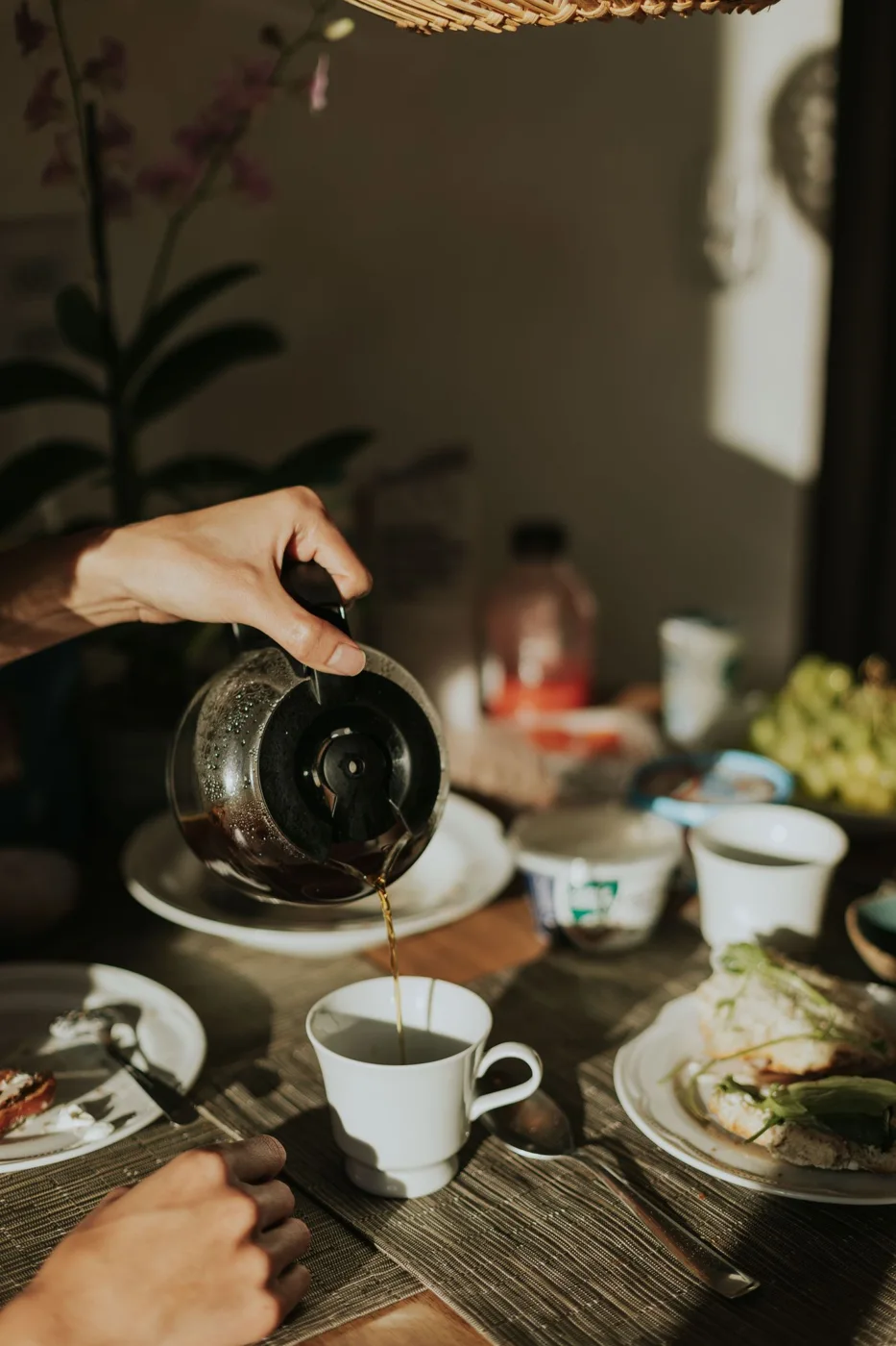 Coffee and breakfast dishes on a shared table.