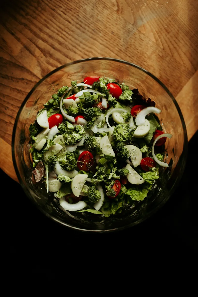 A green salad with tomatoes and cucumber in a bowl.