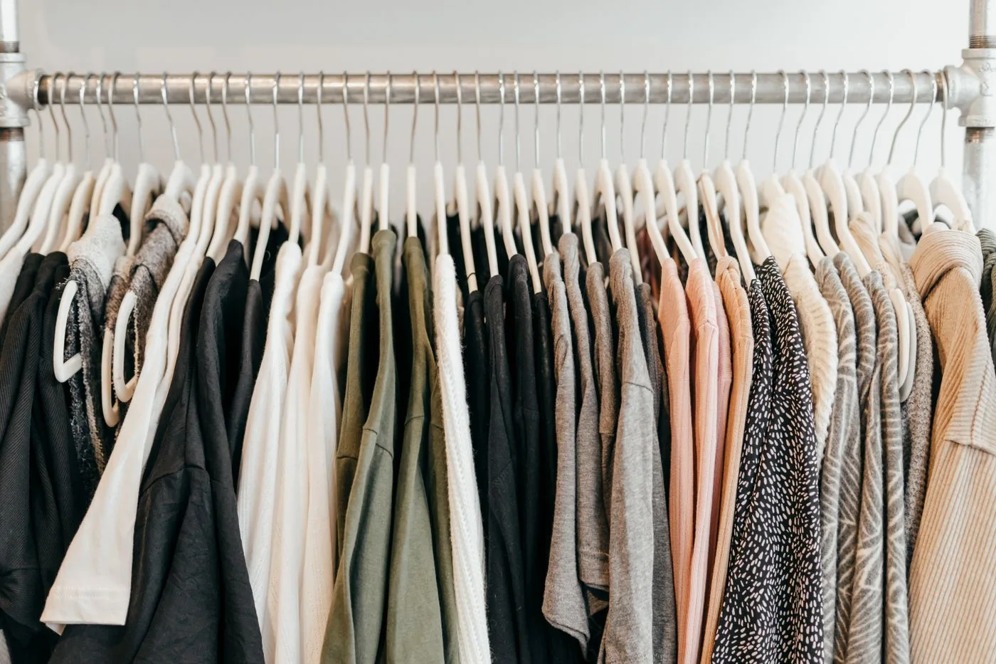 Varied garments hanging on a row of hangers.