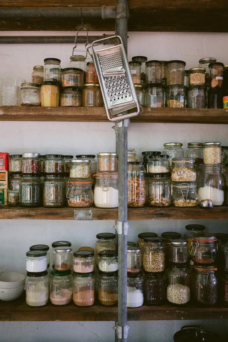 Shelves holding labeled glass jars of dry ingredients.