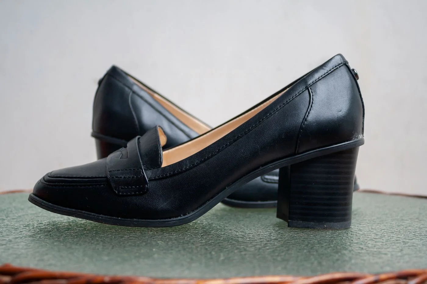 Black leather slip-on shoes with low block heels.