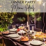 An outside table near a beautiful wooded area with places set for a dinner party and food staged on the table.