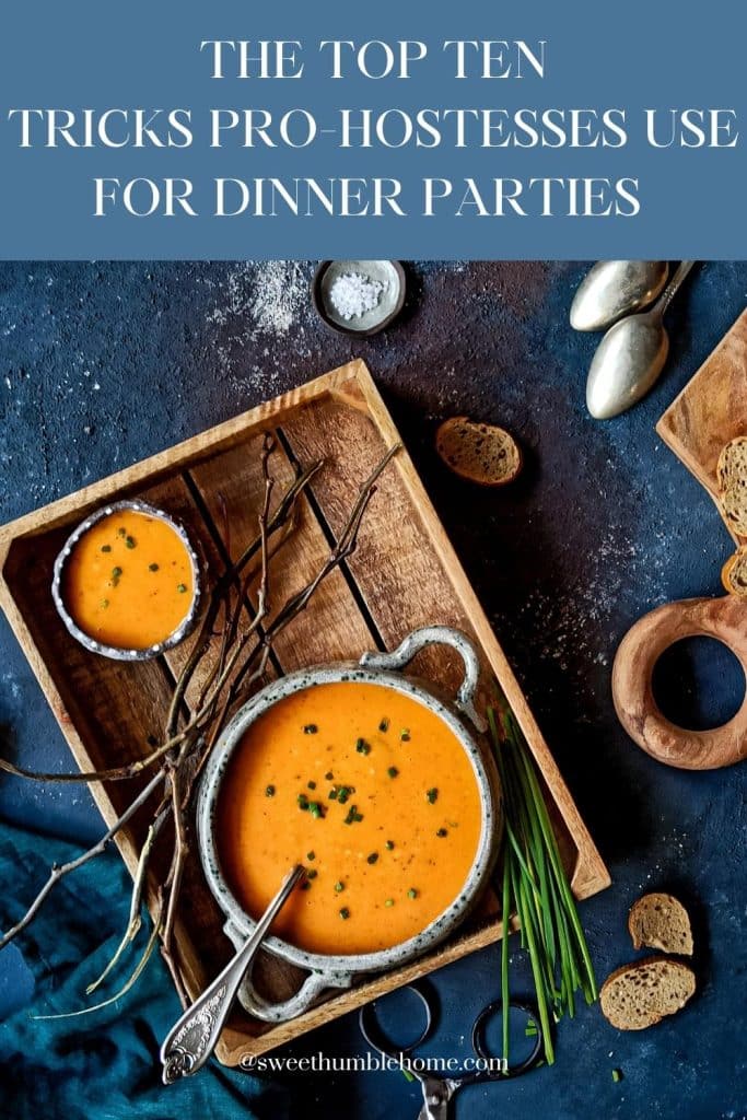 Butternut squash soup in a bowl and a small cup on a wooden tray on top of a blue background.